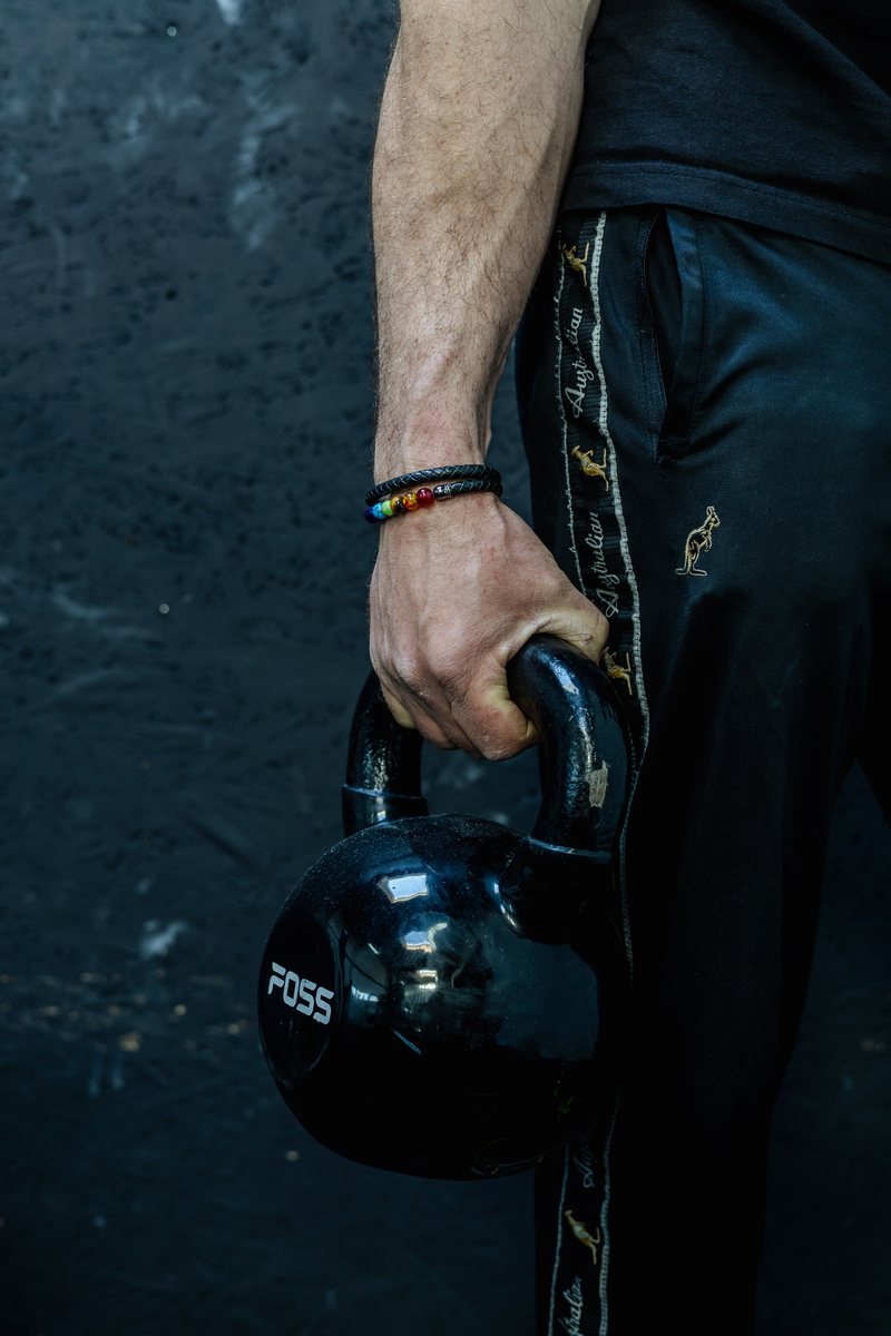 Hand grijpt een kettlebell — grip, spanning en belasting onder controle